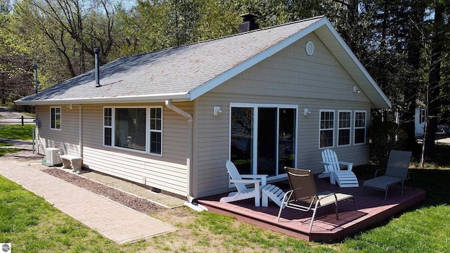 10701 SW Torch Lake Dr, Rapid City, MI 49676 - rear view of property featuring central air condition unit, a deck, and a chimney