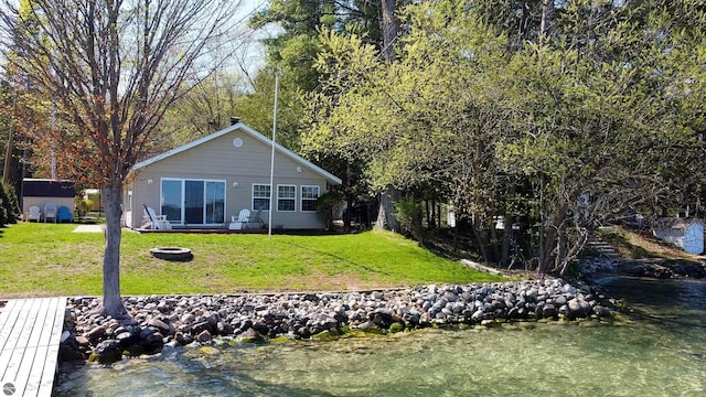 10701 SW Torch Lake Dr, Rapid City, MI 49676 - back of property featuring an outdoor fire pit, a yard, an outdoor structure, and a storage unit