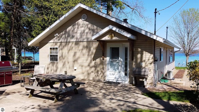 10701 SW Torch Lake Dr, Rapid City, MI 49676 - view of front facade with a patio, outdoor dining area, and central AC
