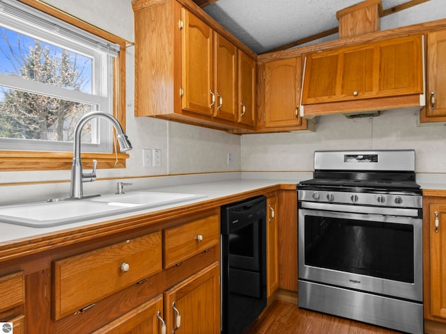 5891 N 19th Rd, Mesick, MI 49668 - kitchen with stainless steel gas stove, black dishwasher, a sink, brown cabinets, and light countertops