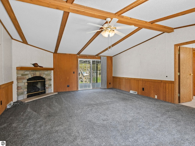 5891 N 19th Rd, Mesick, MI 49668 - unfurnished living room featuring wood walls, a wainscoted wall, a fireplace, a ceiling fan, and carpet
