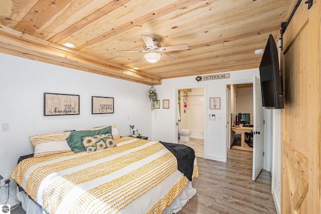 9266 Kenyon Trl, Frederic, MI 49733 - bedroom with wooden ceiling, wood finished floors, a barn door, and ensuite bath