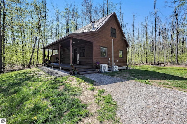 9266 Kenyon Trl, Frederic, MI 49733 - view of property exterior with covered porch, a yard, metal roof, and a cooling unit