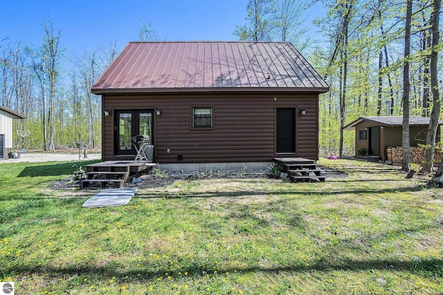9266 Kenyon Trl, Frederic, MI 49733 - back of house featuring faux log siding, a yard, metal roof, and entry steps