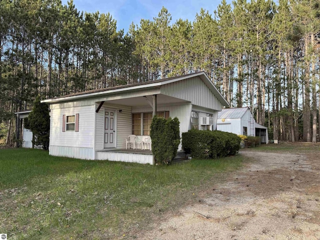 2737 County Road 633, Grawn, MI 49637 - view of front of house with covered porch, dirt driveway, and a front yard