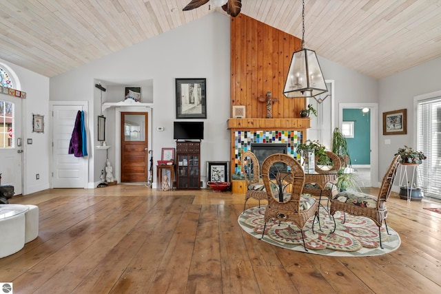 203 W 2nd St, Elk Rapids, MI 49629 - dining room featuring a fireplace, high vaulted ceiling, hardwood / wood-style flooring, ceiling fan, and wooden ceiling