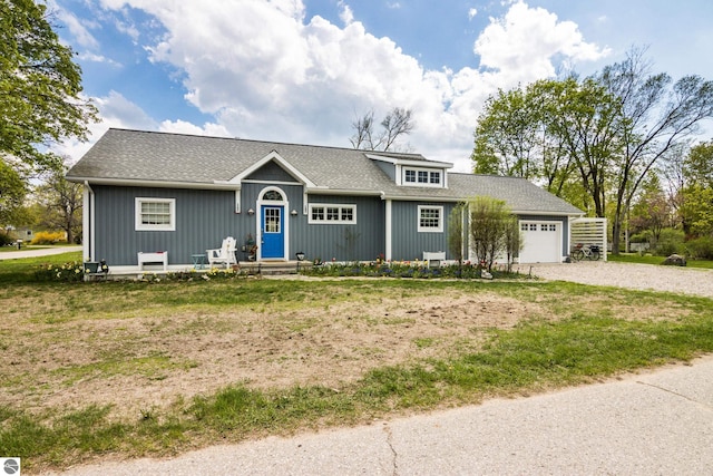 203 W 2nd St, Elk Rapids, MI 49629 - ranch-style home featuring gravel driveway, a garage, a front yard, and a shingled roof