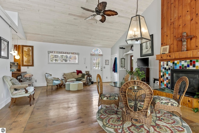 203 W 2nd St, Elk Rapids, MI 49629 - dining room with ceiling fan, wood-type flooring, high vaulted ceiling, a fireplace, and baseboards