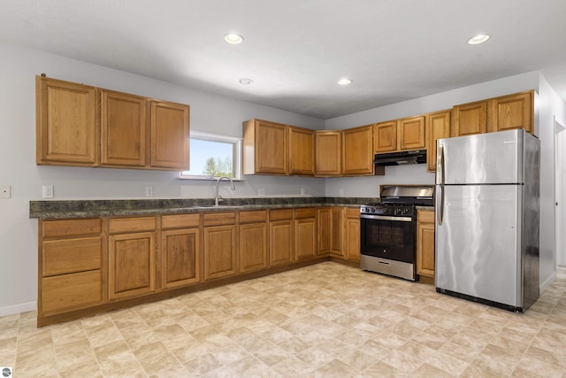 kitchen featuring stainless steel appliances, under cabinet range hood, a sink, brown cabinetry, and recessed lighting