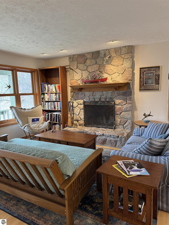 living room with a textured ceiling, wood finished floors, and a fireplace