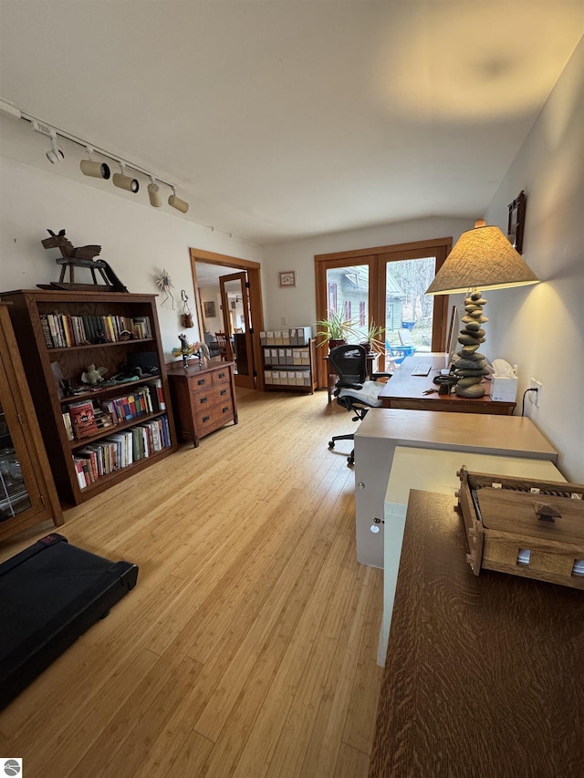 home office featuring rail lighting and light wood-style floors