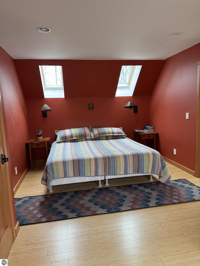 bedroom with a skylight, hardwood / wood-style floors, vaulted ceiling, and recessed lighting