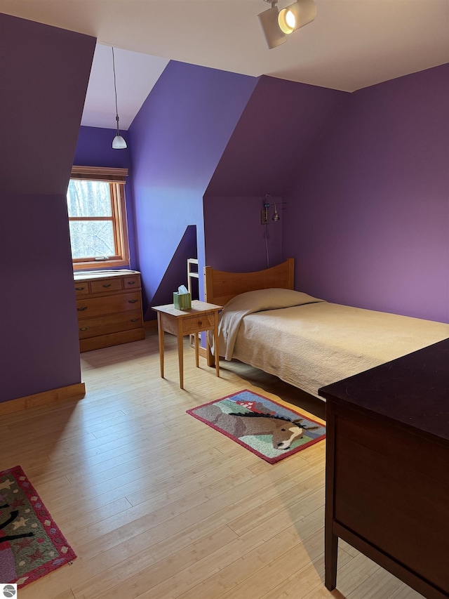 bedroom featuring lofted ceiling and wood finished floors