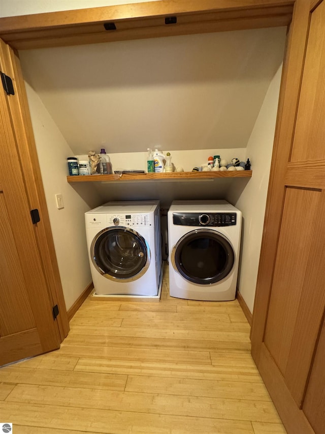 laundry room featuring washer and clothes dryer, light wood finished floors, and baseboards