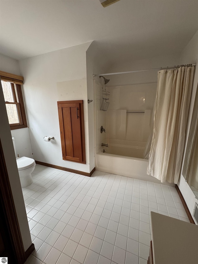 full bath with shower / bath combo, toilet, tile patterned floors, and baseboards