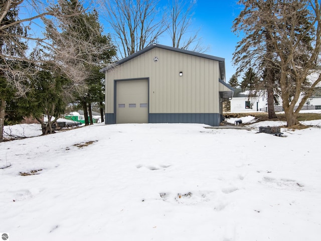 snow covered garage featuring a garage
