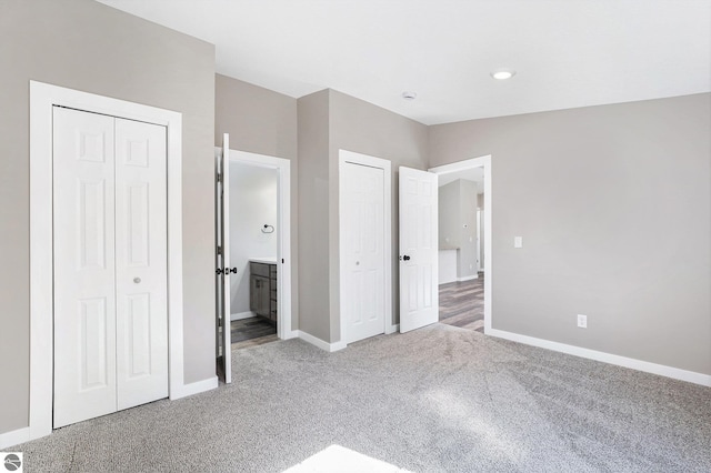 3218 S 41st Rd, Cadillac, MI 49601 - unfurnished bedroom with carpet, multiple closets, baseboards, and ensuite bath