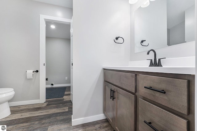 3218 S 41st Rd, Cadillac, MI 49601 - bathroom with wood finished floors, toilet, baseboards, and vanity