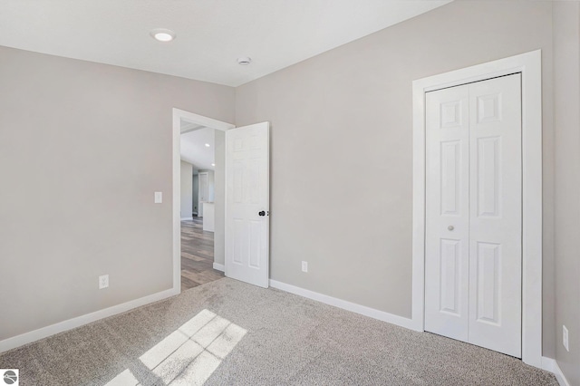 3218 S 41st Rd, Cadillac, MI 49601 - unfurnished bedroom with light colored carpet, baseboards, and a closet