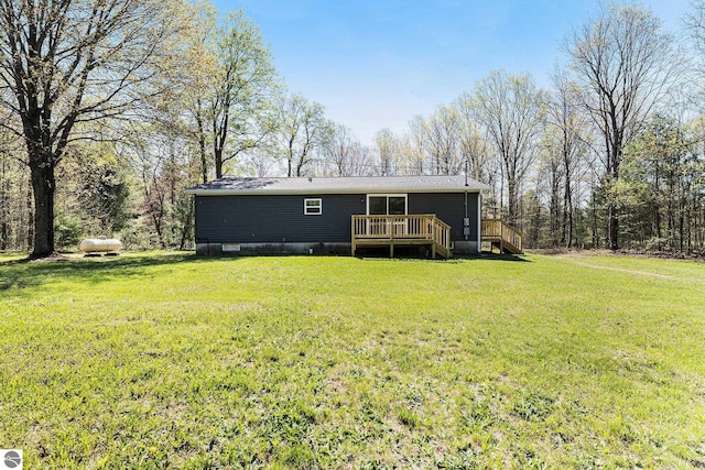 3218 S 41st Rd, Cadillac, MI 49601 - rear view of property featuring a deck, a yard, and stairs