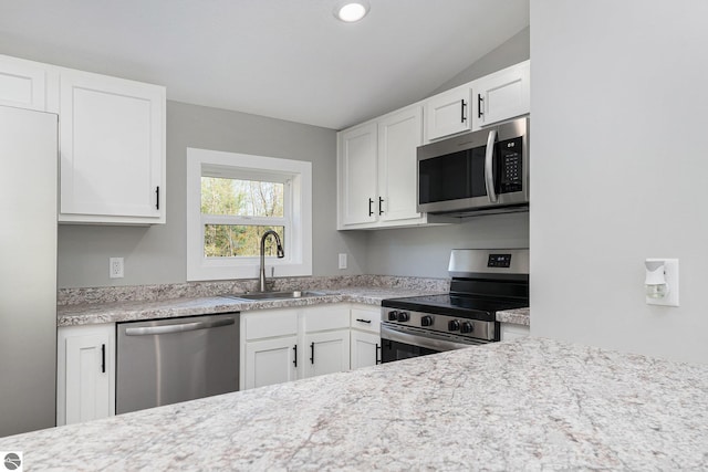 3218 S 41st Rd, Cadillac, MI 49601 - kitchen with stainless steel appliances, a sink, light countertops, white cabinetry, and lofted ceiling