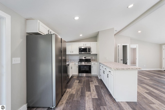 3218 S 41st Rd, Cadillac, MI 49601 - kitchen featuring appliances with stainless steel finishes, a peninsula, dark wood-type flooring, lofted ceiling, and white cabinets