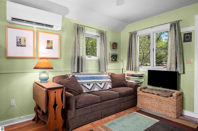 429 S Shabwasung St, Northport, MI 49670 - living room with an AC wall unit, vaulted ceiling, wood finished floors, and baseboards