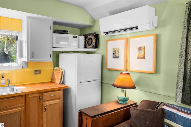 429 S Shabwasung St, Northport, MI 49670 - kitchen with white appliances, a wall mounted air conditioner, butcher block counters, lofted ceiling, and brown cabinetry