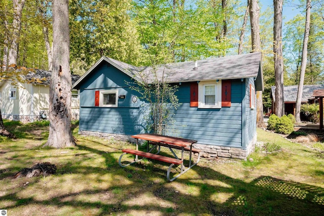 429 S Shabwasung St, Northport, MI 49670 - view of front facade with a front lawn and roof with shingles
