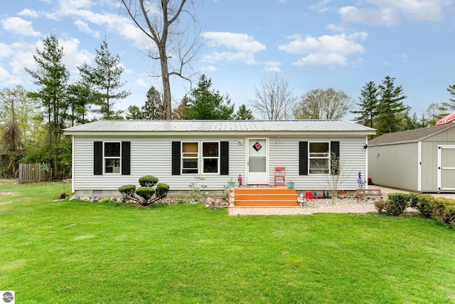 1035 3rd St, Tawas City, MI 48763 - view of front of home with a front lawn and metal roof