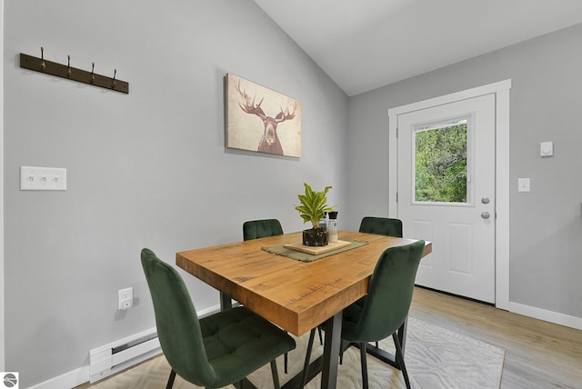 dining room featuring lofted ceiling, baseboards, and light wood-style flooring