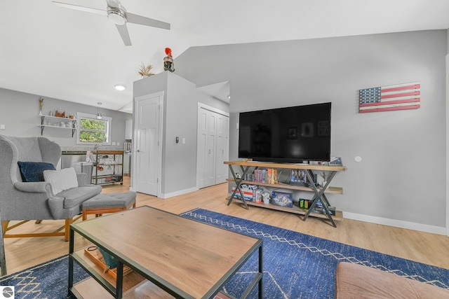 living area with a ceiling fan, wood finished floors, baseboards, and vaulted ceiling
