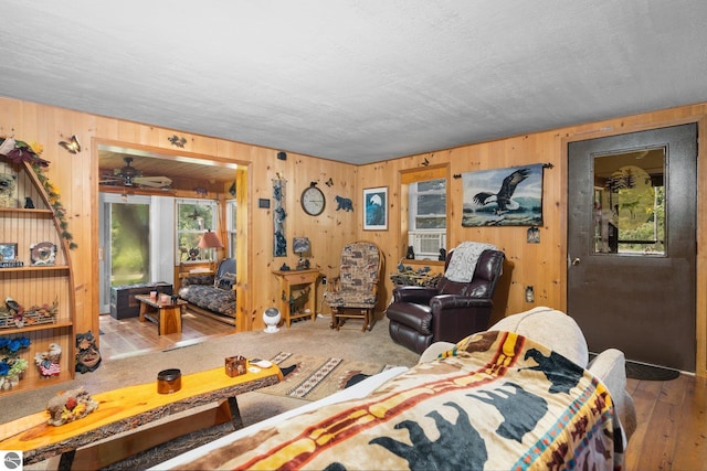 6202 Fletcher Rd, Fife Lake, MI 49633 - living area with wood walls, ceiling fan, and hardwood / wood-style flooring