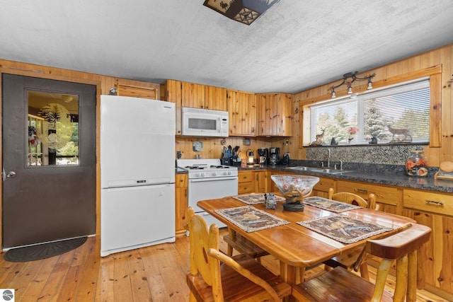 6202 Fletcher Rd, Fife Lake, MI 49633 - kitchen featuring white appliances, a sink, dark countertops, backsplash, and light wood-style flooring