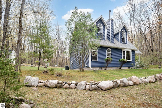 4480 Mockingbird Cir, Farwell, MI 48622 - view of side of property with central AC, a yard, a chimney, and roof with shingles