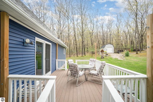 4480 Mockingbird Cir, Farwell, MI 48622 - wooden terrace featuring outdoor dining space, a lawn, and an outdoor structure