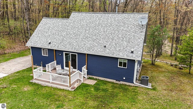 4480 Mockingbird Cir, Farwell, MI 48622 - back of property with a shingled roof, a wooden deck, a lawn, and central air condition unit