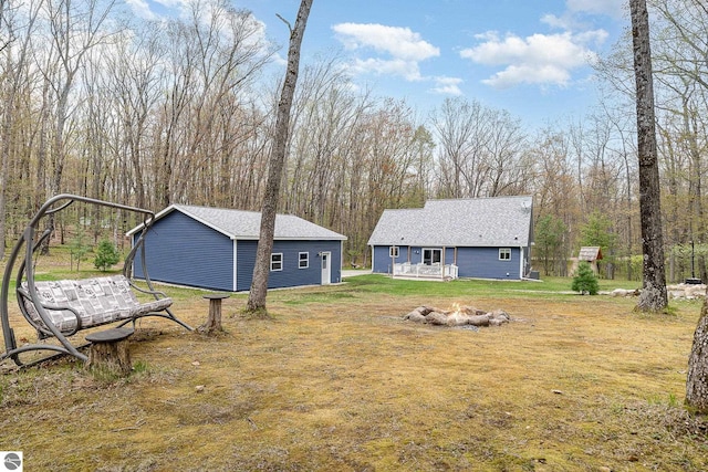 4480 Mockingbird Cir, Farwell, MI 48622 - view of grassy yard featuring an outdoor structure and an outdoor fire pit