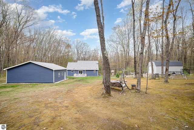 4480 Mockingbird Cir, Farwell, MI 48622 - view of green lawn featuring an outbuilding, a storage unit, and view of scattered trees