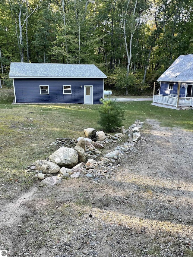 4480 Mockingbird Cir, Farwell, MI 48622 - view of grassy yard with an outbuilding and a view of trees