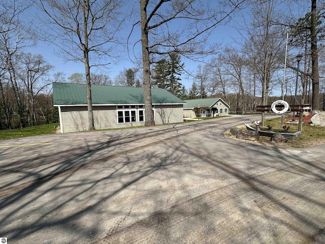 4480 Mockingbird Cir, Farwell, MI 48622 - view of side of property featuring metal roof and asphalt driveway