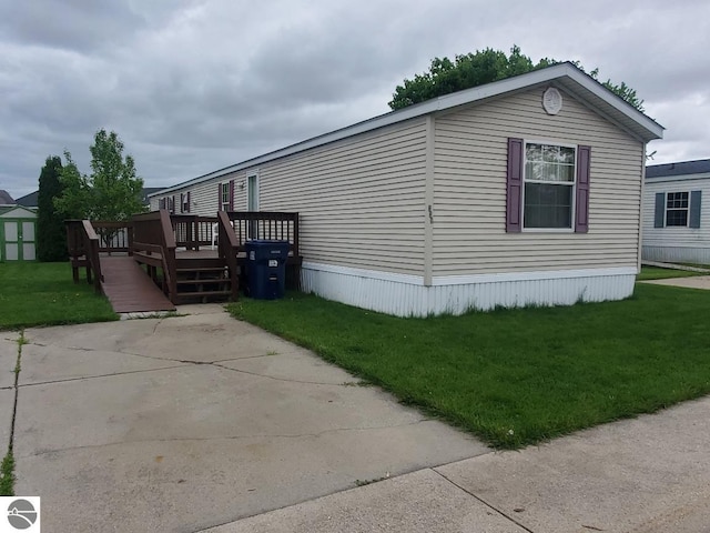 5232 E Broadway Lot 338, Mount Pleasant, MI 48858 - view of property exterior featuring a deck and a lawn