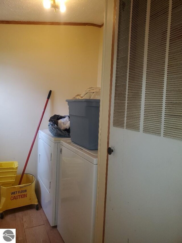5232 E Broadway Lot 338, Mount Pleasant, MI 48858 - laundry room with washing machine and dryer, a heating unit, crown molding, and wood finished floors