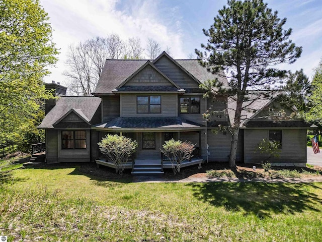 craftsman-style house featuring a front lawn, a shingled roof, and a chimney