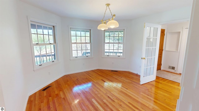 unfurnished room featuring light wood-type flooring, baseboards, and french doors