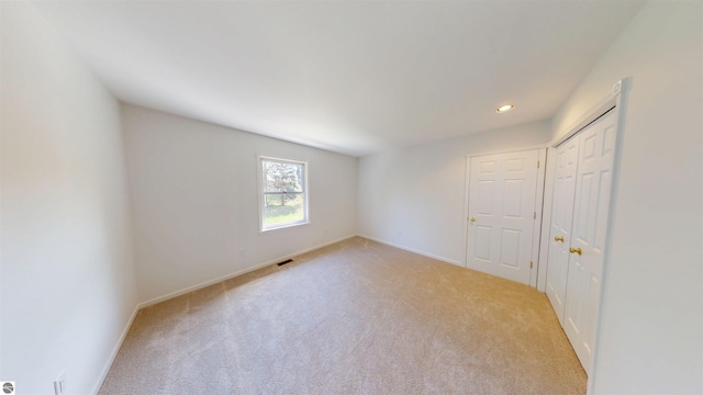 unfurnished bedroom with carpet floors, baseboards, recessed lighting, and a closet