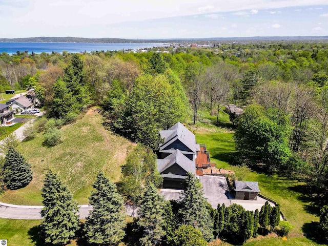 view of subject property with a heavily wooded area and a nearby body of water