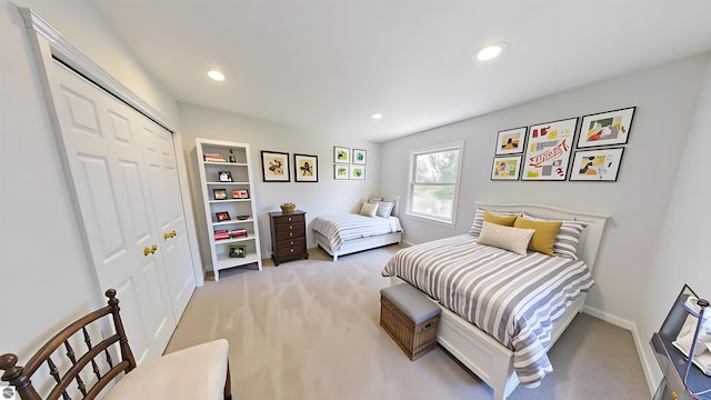 bedroom featuring light colored carpet, baseboards, recessed lighting, and a closet