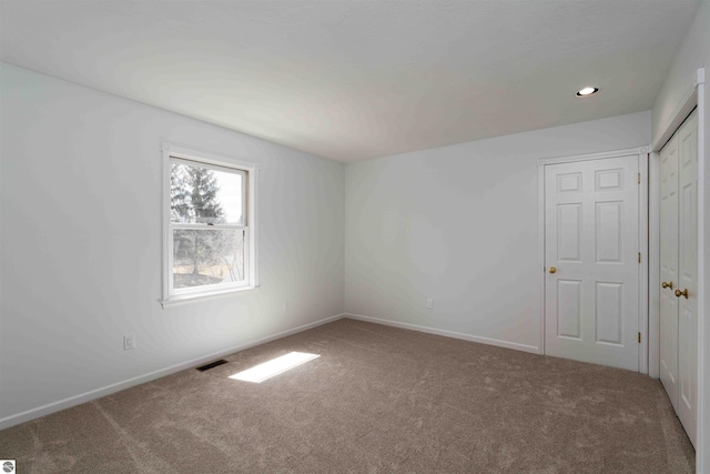 empty room with carpet, baseboards, and recessed lighting