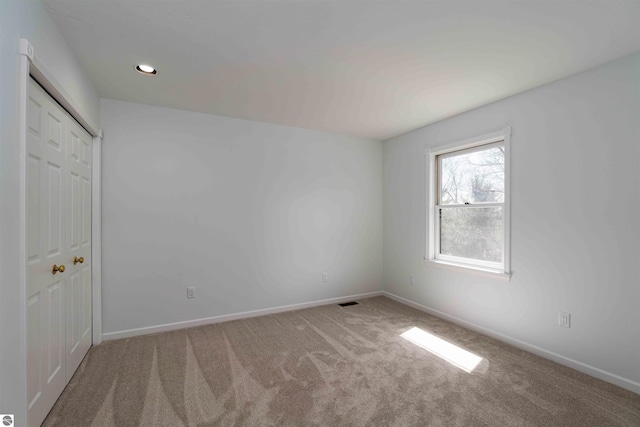 unfurnished bedroom with carpet flooring, baseboards, and a closet